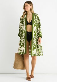 Green and white patterned kimono-style cover-up made from lightweight fabric, open front, with three-quarter sleeves and relaxed fit.