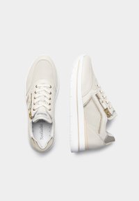 White sneakers featuring a combination of mesh and synthetic leather, gold accents, and a textured design. Side zipper for easy wear.