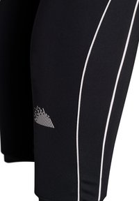 Sorte atletikshorts med hvide accenter, der har et tekstureret logodesign og et tætsiddende, elastisk stof, der giver bevægelsesfrihed.