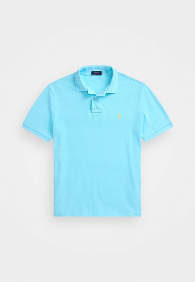 Heledad sinine puuvillane polo särk, millel on klassikaline krae, kahe nööbiga nööpaugus ja rinnal väike tikandiga logo.