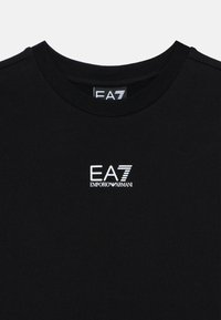 Μαύρο βαμβακερό μπλουζάκι με στρογγυλή λαιμόκοψη, με λευκά λογότυπα EA7 και Emporio Armani στο μπροστινό μέρος. Ομαλή υφή, κοντά μανίκια.