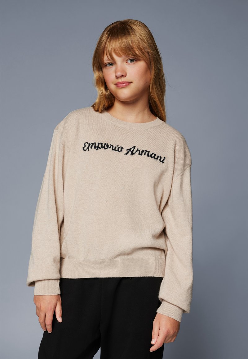 Beige kötött pulóver hosszú ujjakkal, kerek nyakkal és fekete "Emporio Armani" hímzett logóval a mellkasán. Textúrált felület.