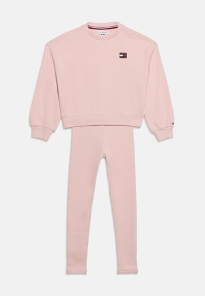 Sweat-shirt rose à manches longues avec leggings assortis, avec un petit logo rectangulaire sur la poitrine et des manches avec poignets.