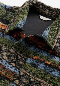 Fleece jack met een mix van groene, oranje en blauwe patronen. Heeft een kraag en gestructureerde stof. Inclusief een zwarte binnenvoering.