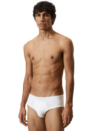 Weiße Baumwollunterwäsche mit einem weichen Bund, in schlichtem Design und mit minimaler Nahtverarbeitung. Der Stoff wirkt glatt und atmungsaktiv.