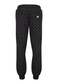 Sorte joggebukser med et subtilt mønster over hele, med elastiske mansjetter og snøring i livet, to baklommer og en liten logo.