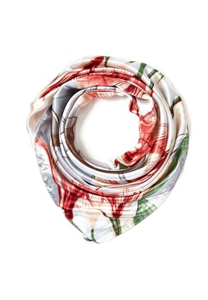 Silkeskærf rullet i en cirkulær form med blomsterprint i rød, grøn, brun og beige på en hvid baggrund.