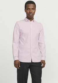 Helles rosa Button-Down-Hemd mit spitzem Kragen, langen Ärmeln und schlanker Passform. Aus glattem Stoff mit subtiler Textur gefertigt.