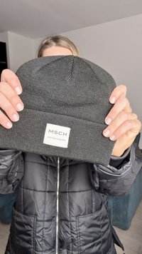 Dark gray knit beanie with a textured design, featuring a sewn-on label that reads "MSCH COPENHAGEN." The fabric is flexible and warm.