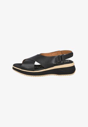Sandalias de cuero negro de punta abierta con correas cruzadas, una correa para el tobillo ajustable y una suela gruesa color tostado con acentos texturizados.