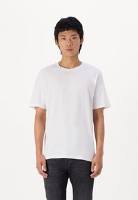 Witte katoenen T-shirt met korte mouwen, ronde halslijn en een relaxte pasvorm. Soepele textuur, minimalistisch ontwerp, zonder zichtbare patronen of accenten.