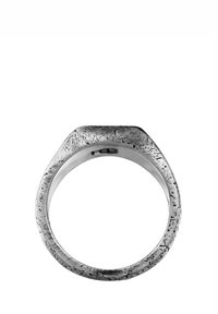 Metallring med en strukturerad yta, rektangulärt topp och polerad insida. Har en robust, mattfinish med intrikata detaljer. Silverfärg.