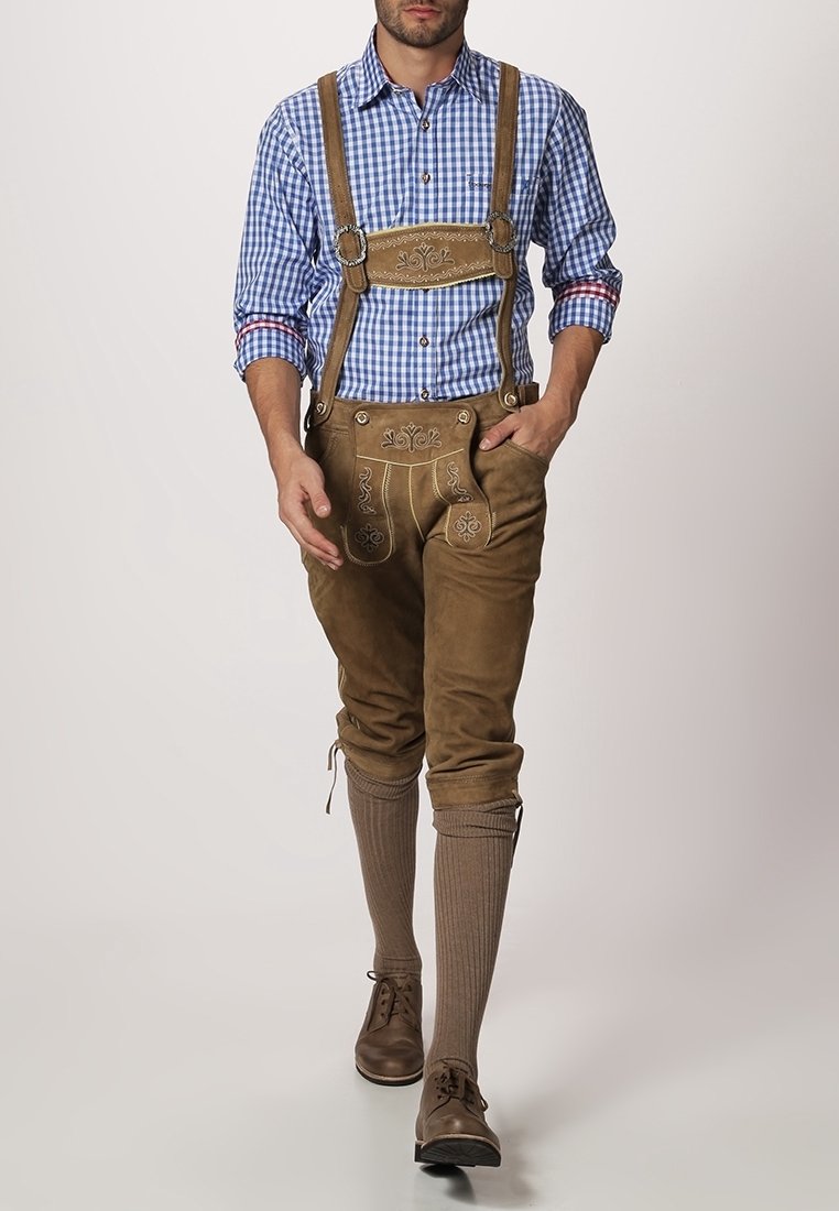 Pantalones de cuero marrón con costuras decorativas, combinados con una camisa a cuadros azul y blanco. Zapatos marrones y calcetas marrones hasta la rodilla completan el atuendo.
