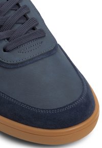 Baskets en daim bleu marine avec tige en cuir lisse, embout rond, fermeture à lacets plats et semelle extérieure en caoutchouc gomme contrastante.