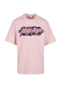 Pink cotton t-shirt featuring a black and pink graphic logo "Karl Kani" in a flame design across the chest. Short sleeves, crew neck.