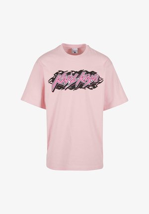 Rosa bomullströja med en svart och rosa grafisk logotyp "Karl Kani" i en flamdesign över bröstet. Kort ärm, rundad hals.
