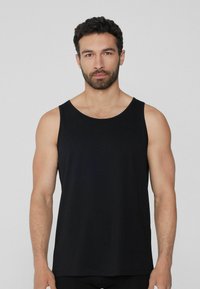 Schwarzes Tanktop aus einem weichen, dehnbaren Stoff. Verfügt über einen runden Ausschnitt und breite Armausschnitte. Einfaches, geradliniges Design ohne Muster oder Akzente.