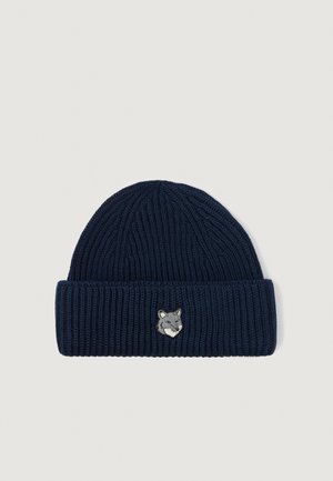 Bonnet en tricot bleu marine avec une texture côtelée et un revers, arborant un petit visage de loup brodé sur le devant.