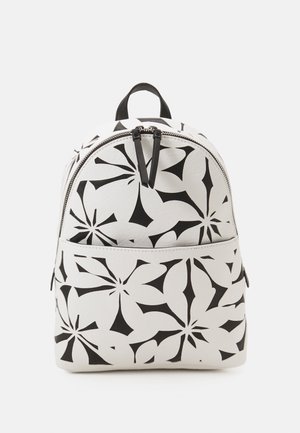 Rucksack mit runder Form, hergestellt aus strukturiertem weißen Material mit einem schwarzen Blumenmuster und einem oberen Reißverschluss. Schwarze Akzente an dem Reißverschluss.