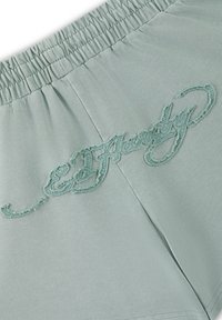 Shorts vert clair avec taille élastique et logo "Ed Hardy" brodé avec un fil assorti sur le tissu.