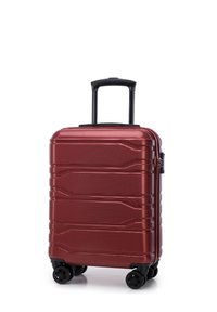 Valise rigide rouge avec une surface texturée, poignée noire extensible, quatre roues et fermeture à glissière. Présente trois rainures horizontales.
