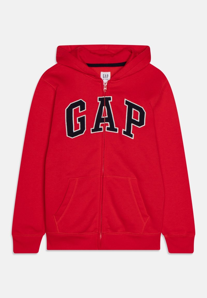 Sweat à capuche rouge pour enfants avec fermeture éclair, poches avant, capuche et grandes lettres noires "GAP" contourées sur la poitrine.