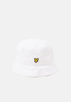 Chapeau seau en coton blanc présentant un logo brodé noir et jaune à l'avant, avec une texture douce et un bord incurvé.