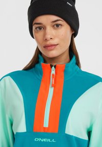 Türkis und Minzgrün Fleece-Pullover mit orangefarbenem Reißverschluss und Kragen. Besitzt Reißverschlussdetails und das O'Neill-Logo auf der Brust.