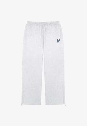 Szare dresy wykonane z miękkiego materiału, z elastycznym pasem, bocznymi kieszeniami i małym akcentem logo po lewej stronie.