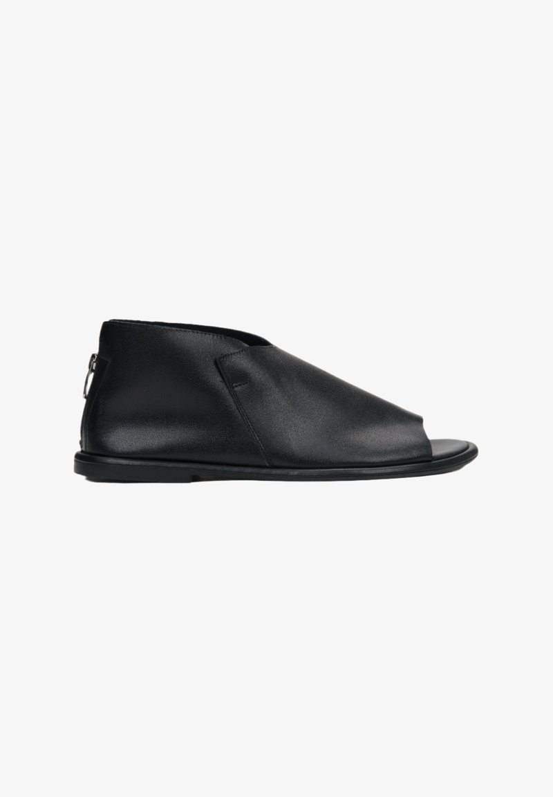 Zwarte leren open teen schoenen met een elegante uitstraling, voorzien van een asymmetrische bovenkant, een lage profiel en een ritssluiting aan de zijkant.