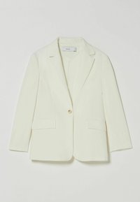 Béžový jednobotoný sak s klopovými límci a dvěma klopovými kapsami, položený na světlém pozadí.