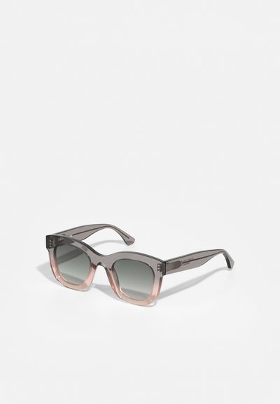 Lunettes de soleil dégradées grises et roses avec une monture rectangulaire. Elles présentent des verres teintés foncés et un logo discret sur la branche.
