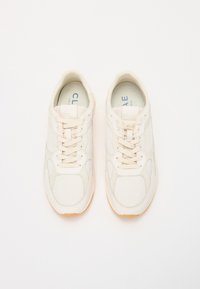 Heledbeez sneakerid, mis on valmistatud hingavast võrgust ja sünteetilisest materjalist, millel on nööpimisega disain, sobivad nöörid ja kummist talla.