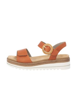 Sandale plateforme en cuir marron avec une boucle circulaire tissée, un design ouvert à l'avant et une semelle texturée, dotée d'une semelle intérieure en mousse beige.