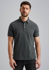 Polo shirt gris foncé en coton, avec un col à trois boutons, des manches courtes et un logo discret sur la poitrine avec un contraste sur le bord.