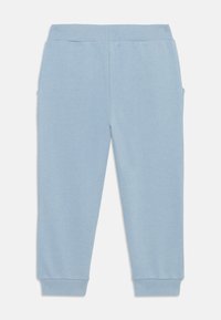 Világoskék, pamut keverékből készült jogging nadrág. Rugalmas derékkal, bordás mandzsettákkal és oldalsó zsebekkel rendelkezik. Sima tapintású.