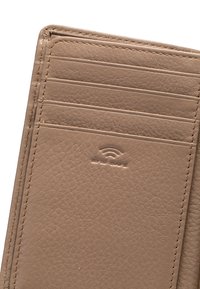 Tan leather wallet with multiple card slots, textured surface, and embossed RFID safety emblem. Detail stitching visible on edges.