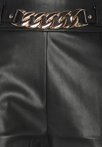 Svarta läderbyxor med ett framträdande metallic guldkedjebälte. Slät textur med synlig sömnad och en hög midja design.