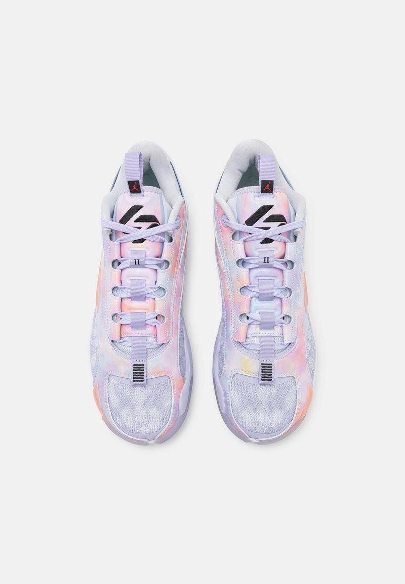 Zapatillas multicolores con una parte superior brillante e iridiscente. Las características incluyen una malla texturizada, seis bucles de cordones y una suela blanca gruesa.