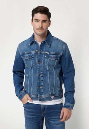 Jachetă din denim de culoare albastru mediu, cu închidere prin butoane în față, două buzunare pe piept și detalii de cusătură contrastante. Croială normală, guler standard.