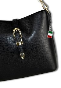 Zwarte leren handtas met een gestructureerde textuur, gouden hardware en een decoratieve sleutelhanger met een charm van de Italiaanse vlag. Inclusief een gespdetail.