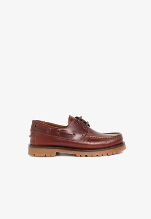 Scarpa da barca in pelle marrone con finitura liscia, punta tonda e suola in gomma marrone a contrasto. Presenta un design con lacci e occhielli in metallo.