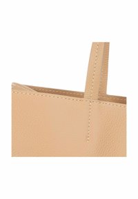 Beige leren tote bag met een textuurafwerking, dubbele korte handvatten en zichtbare stiksels op de randen. Eenvoudige, rechthoekige vorm.