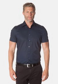 Kurzärmeliges Hemd mit Knöpfen aus dunkelblauem Stoff mit glatter Textur. Verfügt über einen Standardkragen und schwarze Knöpfe, kombiniert mit schwarzer Hose.