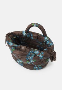 Vatterad brun tygväska med blå blomsterdesign; rundad topp, korta handtag, avtagbar rem, och ett innerfack med dragkedja.