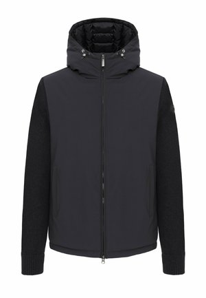 Veste noire à capuche avec fermeture éclair sur toute la longueur à l’avant, corps lisse matelassé, manches en maille, poignets côtelés et cordons de serrage au col.