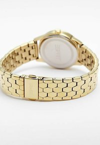 Guldtonad armbandsur med en länkad band med hexagonala länkar, ett runt boett och en slät baksida. Inga synliga markeringar eller detaljer på urtavlan.