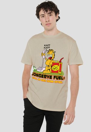 Beige cotton t-shirt featuring a cartoon cat holding a phone, with text "Conserve Fuel: Call in Sick More Often" in colorful print.