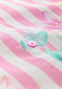 Tela con estampado floral y rayas rosas y blancas. Presenta un botón rosa claro en el centro, que muestra una textura suave y colores vibrantes.