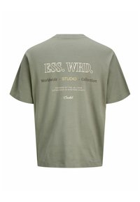Λαδί πράσινο κοντομάνικο μπλουζάκι με λευκό και κίτρινο κείμενο "ESS. WRD. Worldwide Studio Collection" στην πλάτη.